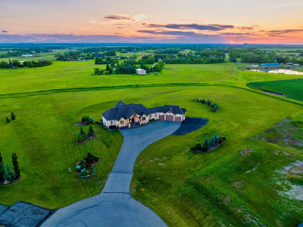 Aerial view of a custom acreage home on two landscaped acres in Eagle Hill, Mountain View County